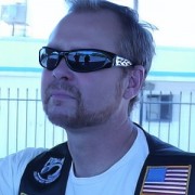 Man with receding blond hair and facial hair, wearing sunglasses